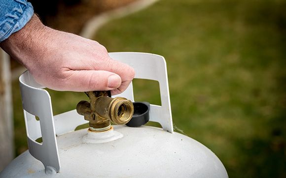 person shutting of the valve of a propane tank